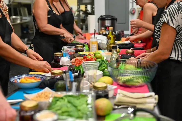 A cooking class at AfroGourmets: fresh vegetables, spices and jars laid out on a long table