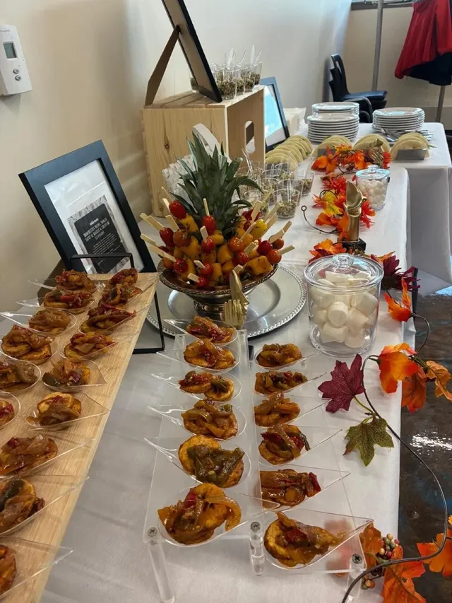 AfroGourmets catering spread with plated bites, a pineapple fruit display and autumn decorations